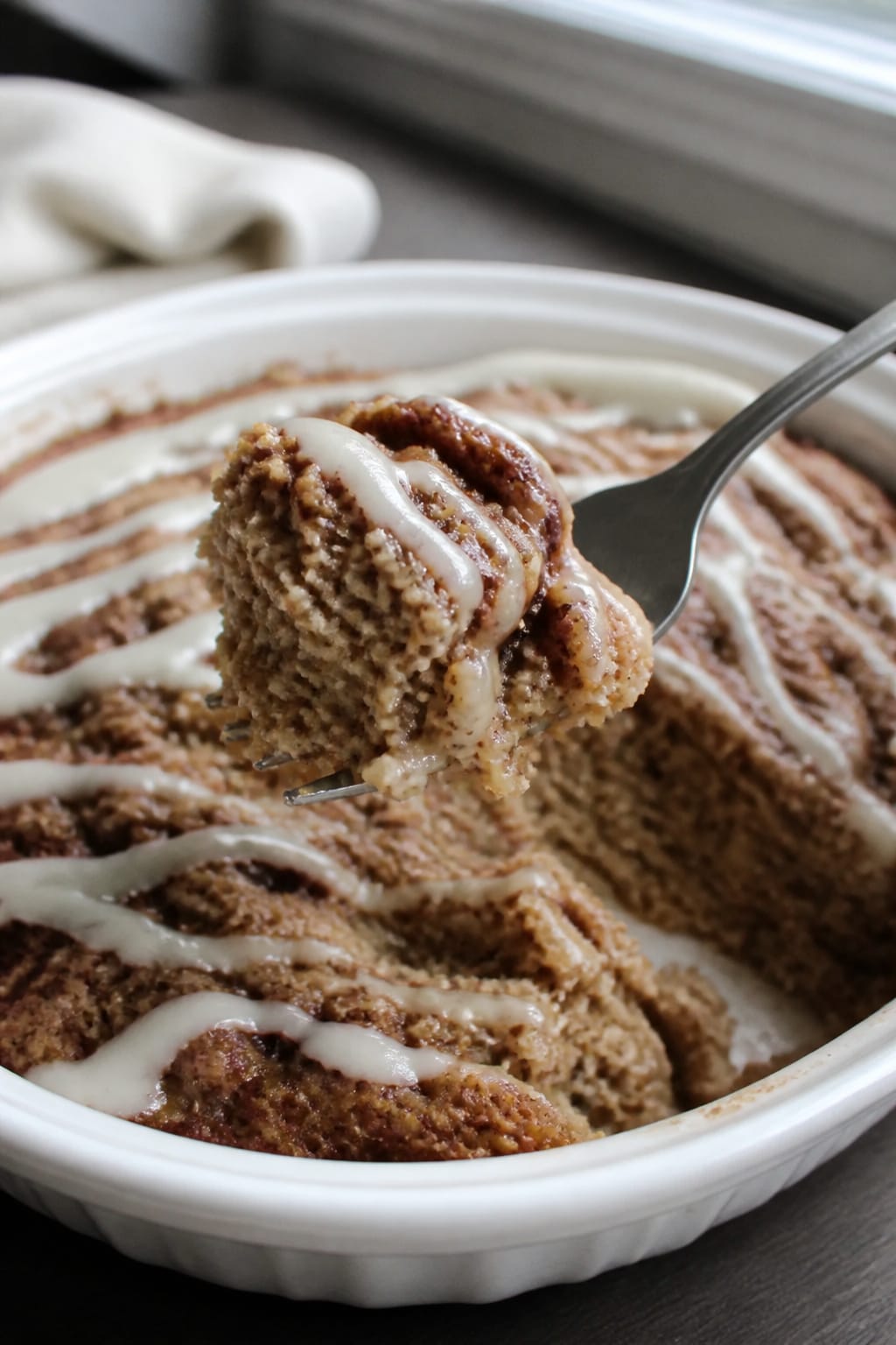 Cinnamon Roll Baked Oatmeal With Cream Cheese Drizzle 2 Same recipe photoshoot, same home kitchen, same natural window light, same smartphone camera style,